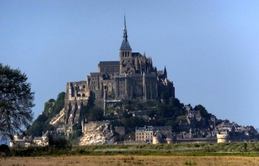 Visitors to Mont St. Michel see it first from miles away as a small mountain looming above some of the flattest terrain is France. This is a telephoto view from the visitors parking lot a mile-and-a-half from the island.